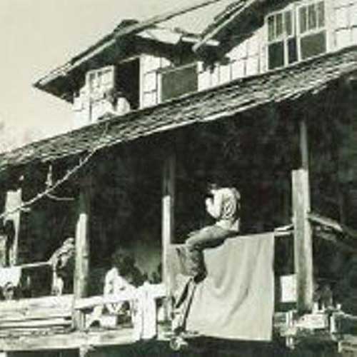 Children play on the veranda of an old house.