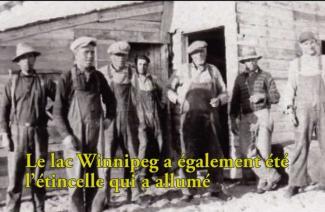  Very old image of men wearing overalls and caps, standing outside a building.